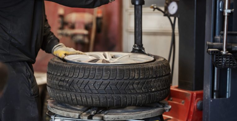 Cropped picture of mechanic service worker working with vulcanizing equipment at vulcanizing workshop.